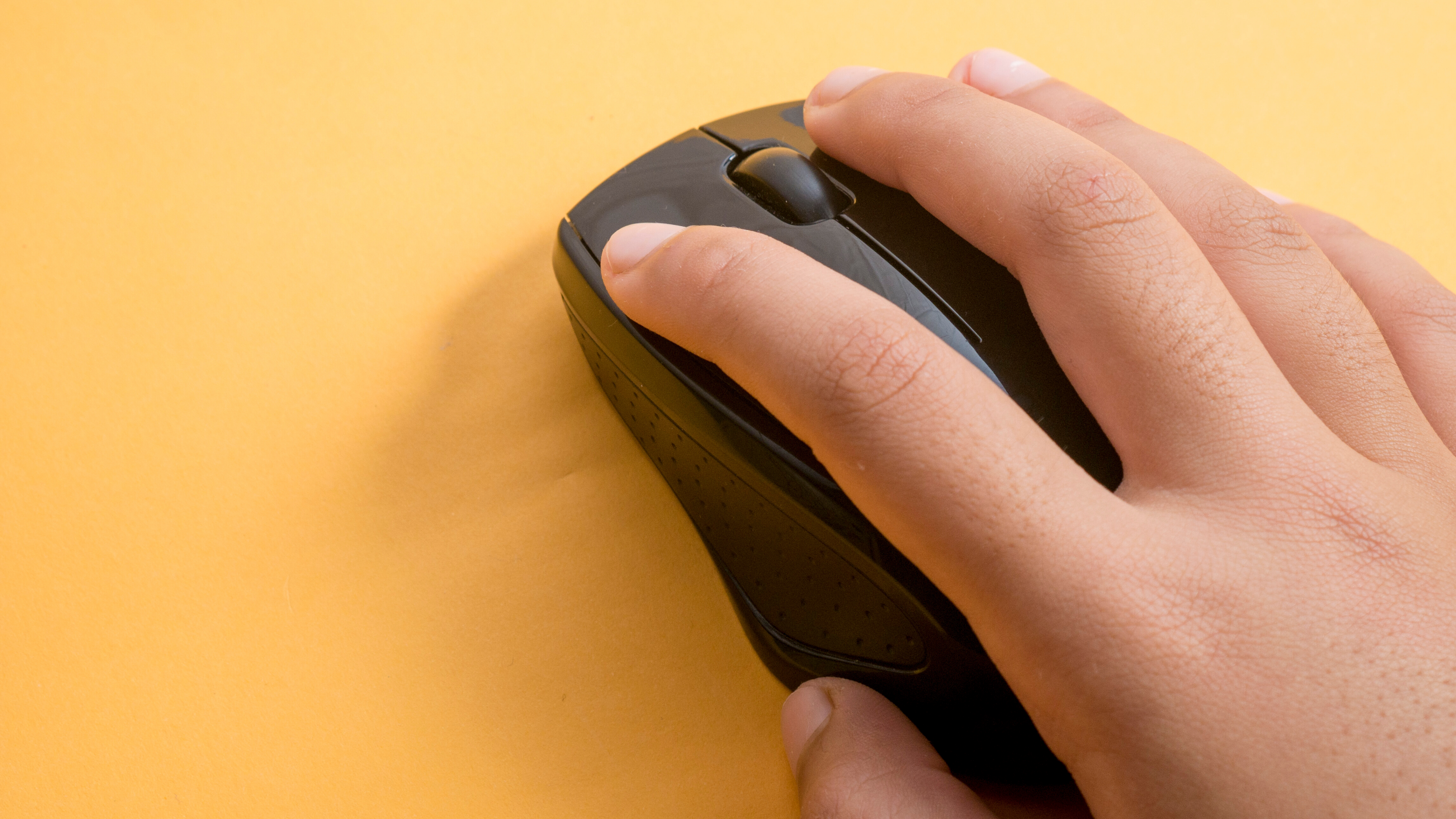 A hand clicking on a mouse